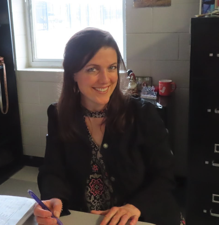 Lindsay Naramore smiling at her classroom desk